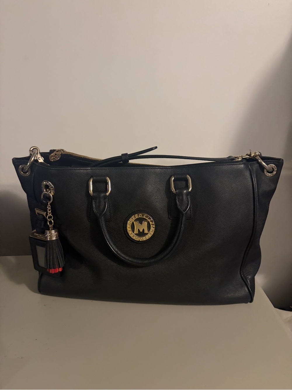 Metrocity Black Leather Tote with Gold Emblem and Tassel Charm